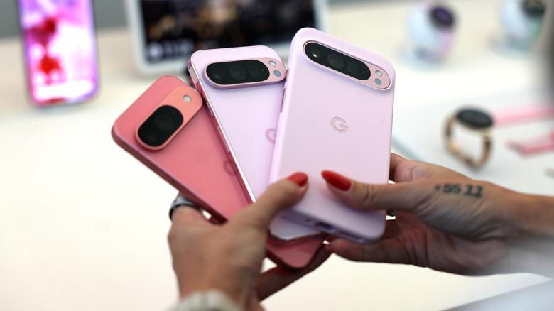 Pixel phones held in hand showing full fleet in pink