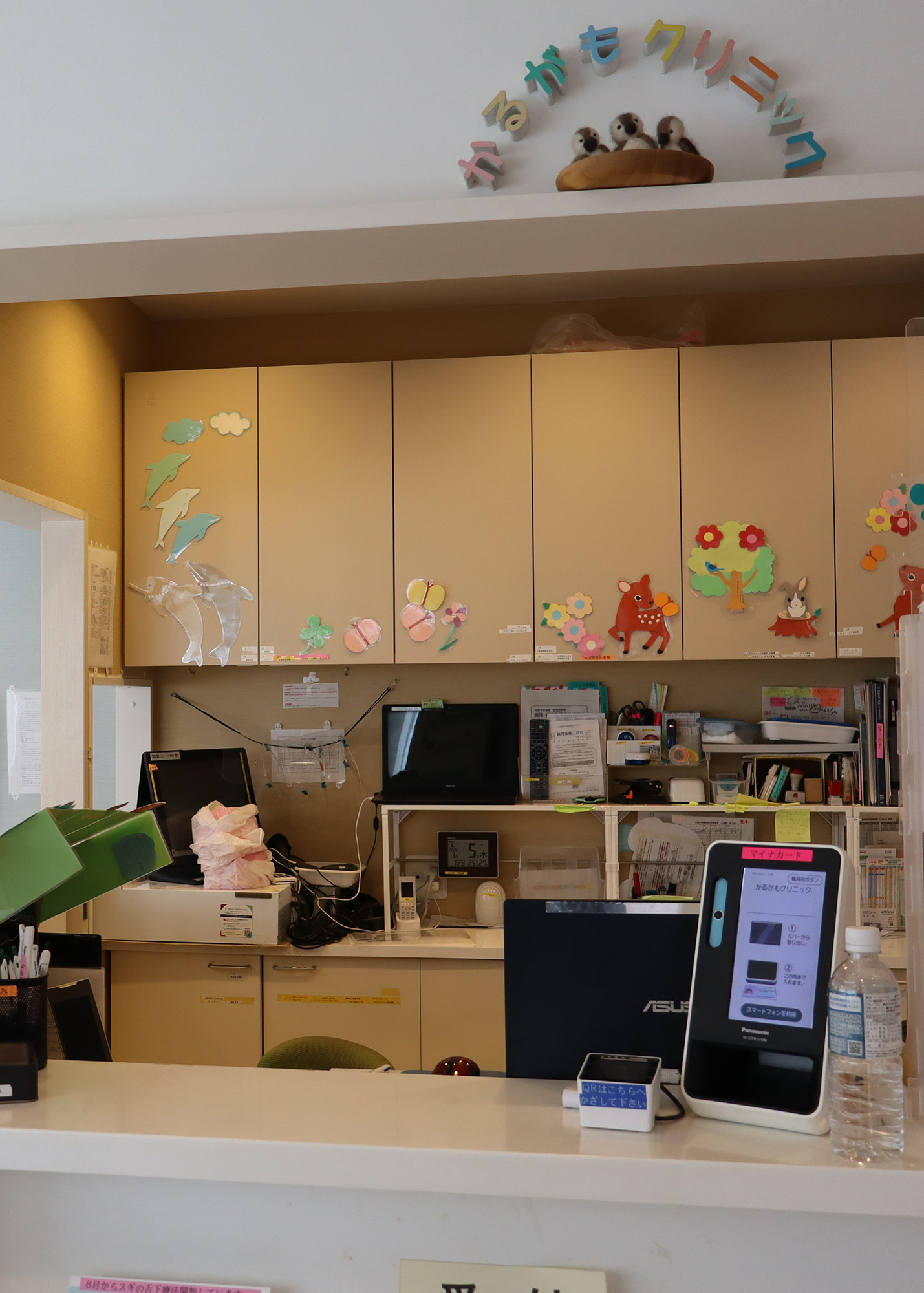 the welcome desk of a pediatric clinic in Japan, decorated with colorful drawings of animals