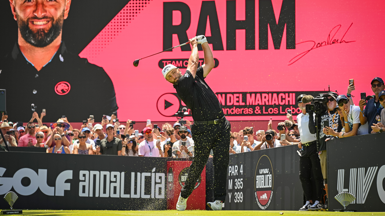 Jon Rahm hits a tee shot in front of crowds