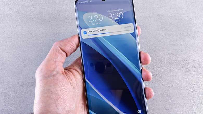 Man holding Android smartphone downloading an update