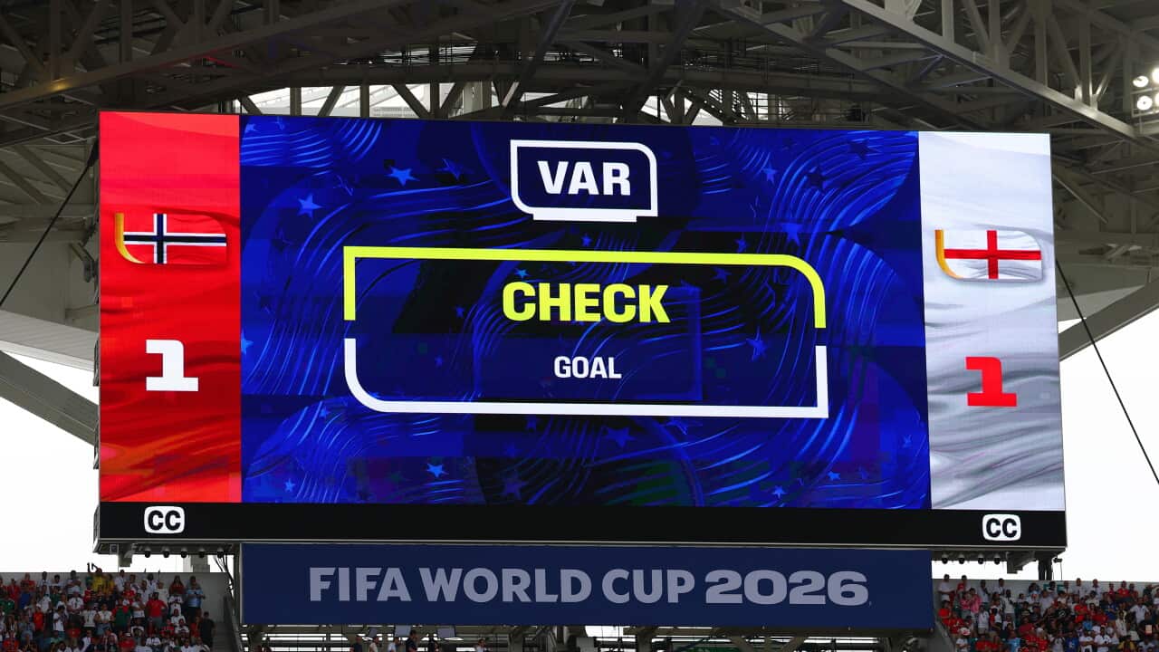 A large screen shows results during a FIFA World Cup match