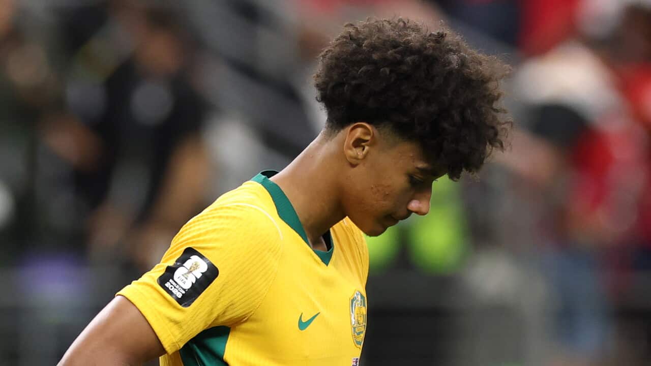 Socceroos player ooks down while lifting the front of his jersey after Australia's World Cup round-of-16 loss to Egypt.