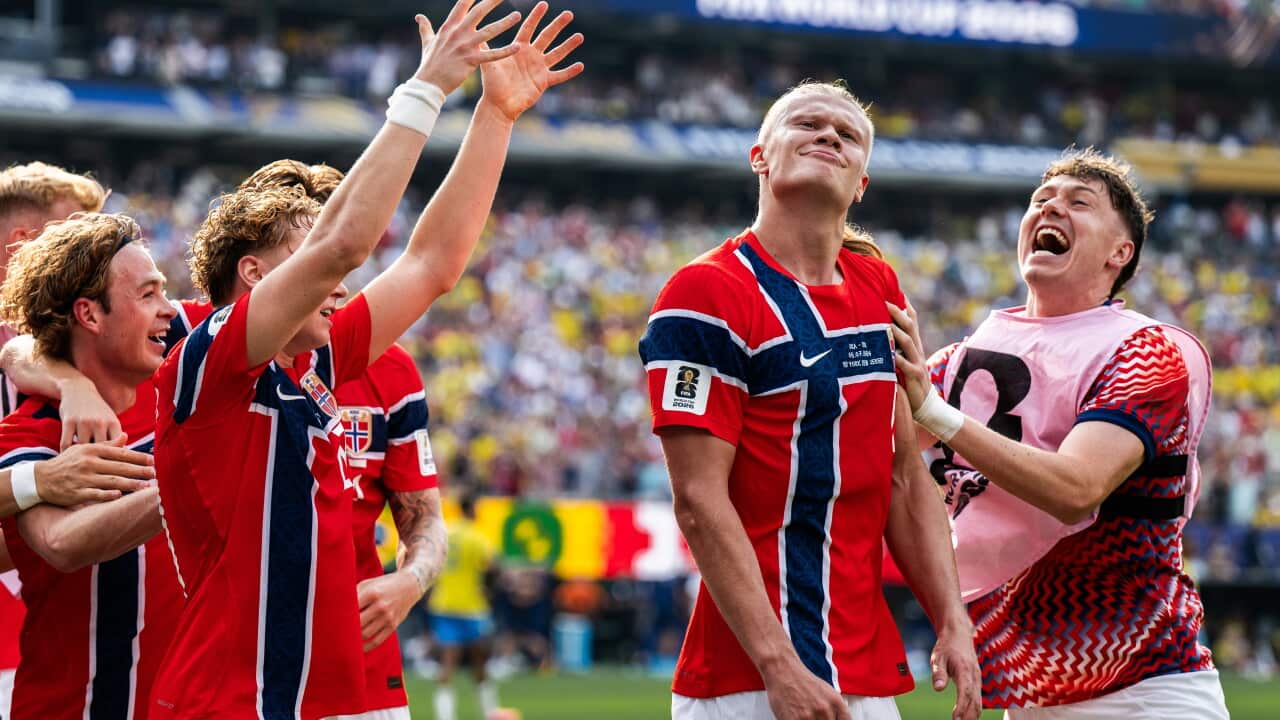 Norwegian footballer Erling Haaland, dressed in Norway's red white and blue uniform, celebrates a goal with his team mates.