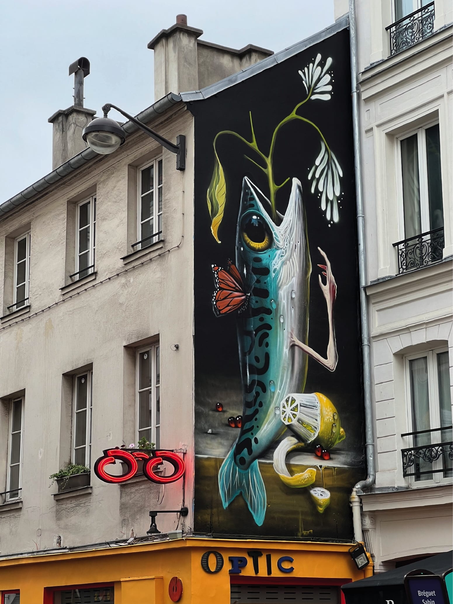 a tall, narrow mural of a fish with flowers coming out of its mouth