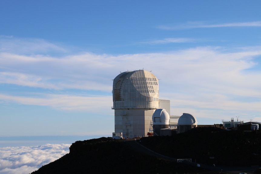 Pale domed building on sunny hilltop.
