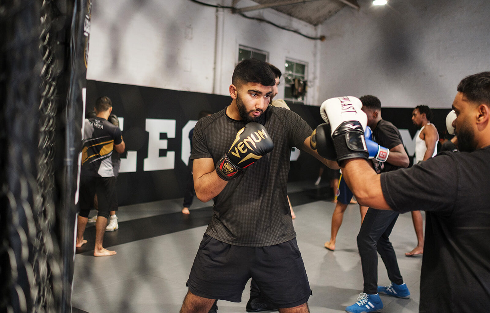 Muhammed Eesa, wearing Venum-branded boxing gloves, sparring during a training session at Legends MMA and Fitness Centre, Luton