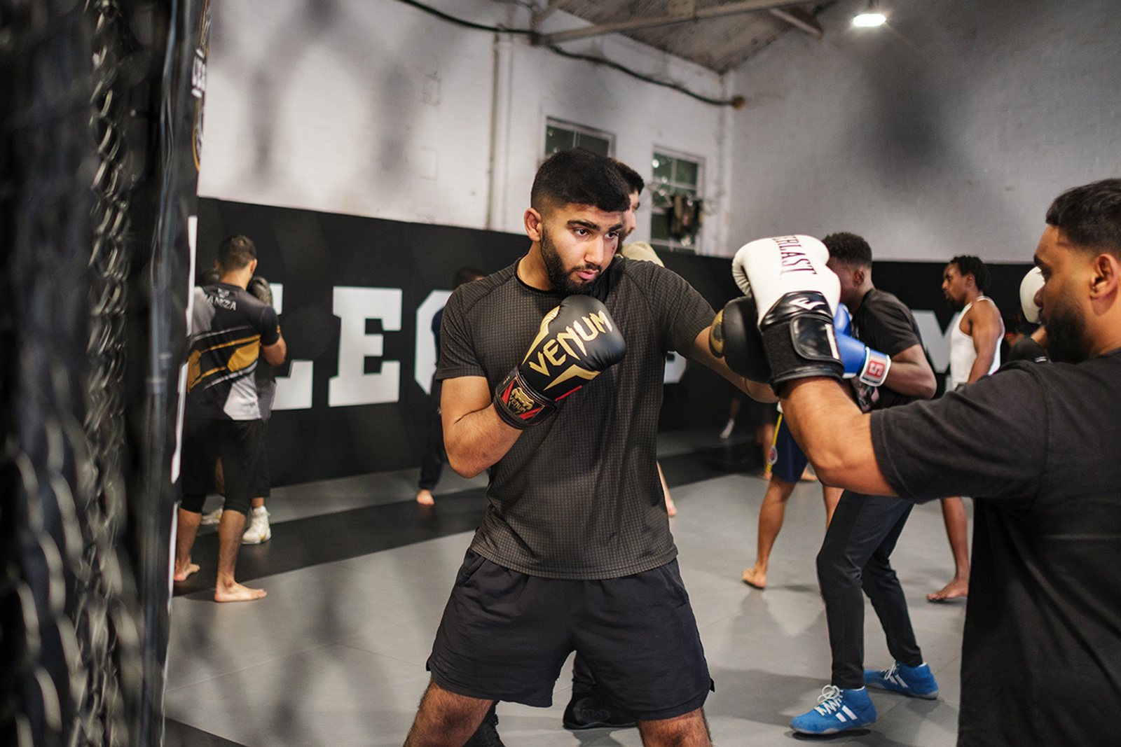 Muhammed Eesa, wearing Venum-branded boxing gloves, sparring during a training session at Legends MMA and Fitness Centre, Luton