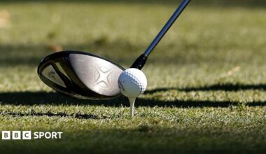 An image of a golf club and golf ball on a tee