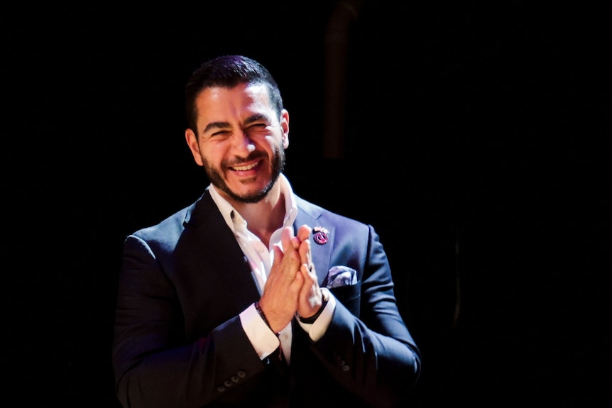 Abdul El-Sayed smiles and presses his hands together.