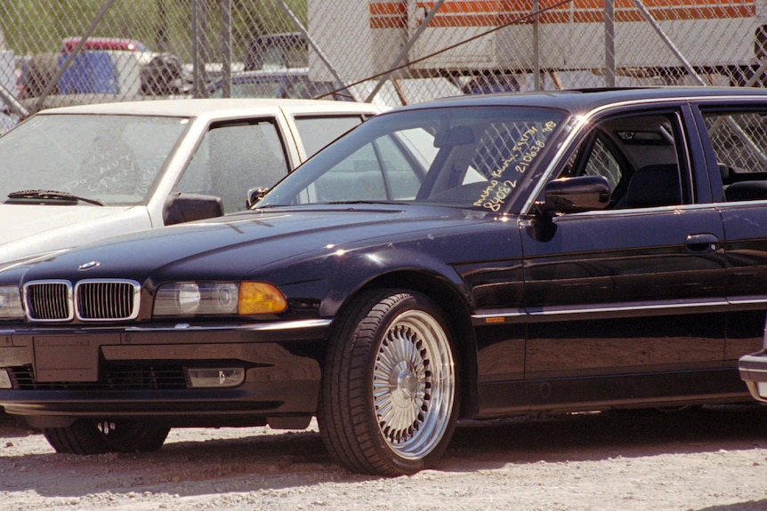 A black BMW with bullet holes near the drivers side door