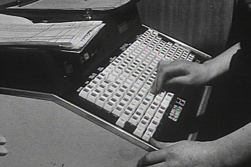 A black and white close up image of a large keyboard-style computer from 168