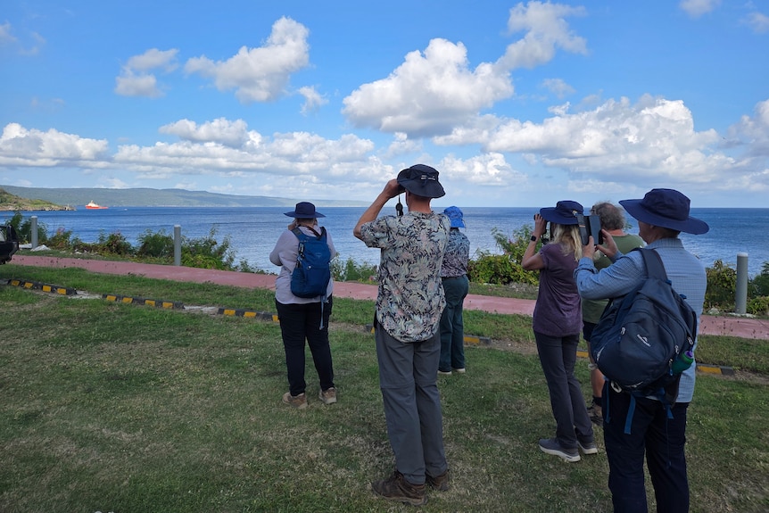 A group of people looking through binoculars