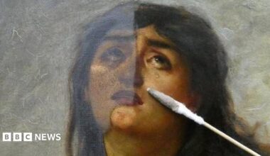 A close up of the painting showing a woman's face. She looks to be stricken by grief and her eyes are looking upwards and she has tears on her cheeks. A conservator's brush-like tool lies on a restored section of the painting.
