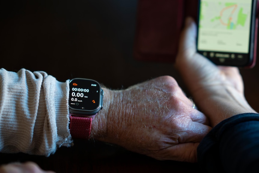A watch on a hand and a phone.