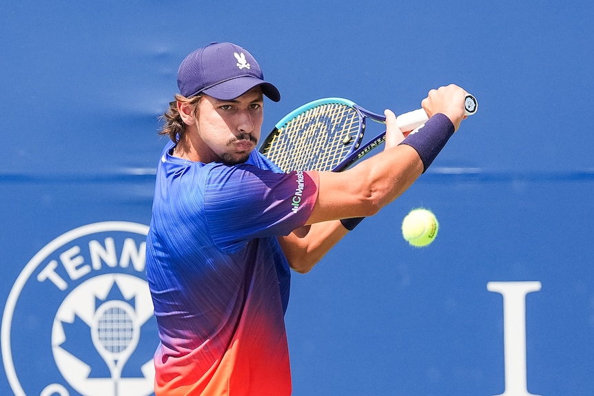 Alexei Popyrin prepares to hit a shot