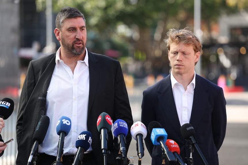 Dean Cox and Callum Mills stand at a lecturn.