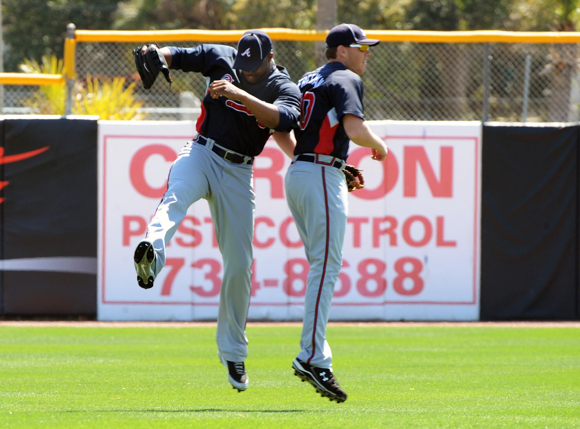 Outfielder Jason Heyward, left, and infielder Freddie Freeman celebrate before play against the Blue Jays March 14, 2010.