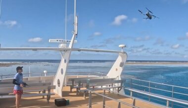 A person launching a drone from a boat to conduct a reef survey
