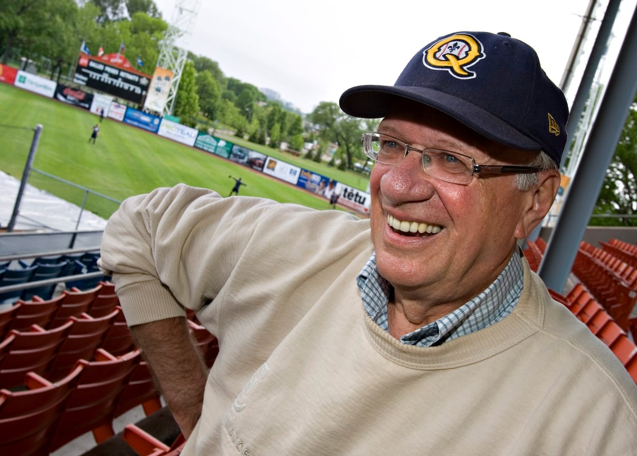 A man in a baseball cap grins at the camera.