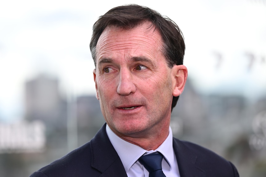 AFL chief executive Andrew Dillon looks to the side during a press conference.