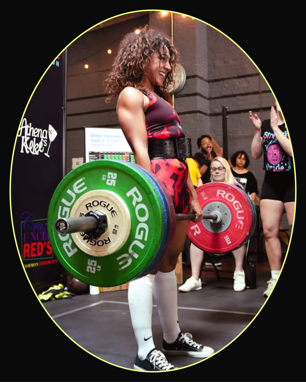 A weightlifter prepares to lift a heavy barbell while an audience cheers in the background.