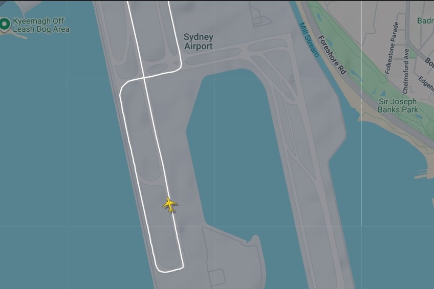 A radar map showing a yellow plane shape on a runway path at Sydney Airport.
