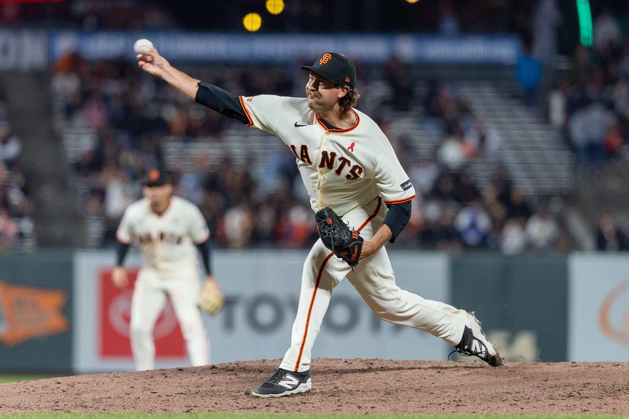 64) throws a pitch during the ninth inning against the Houston Astros at Oracle Park.