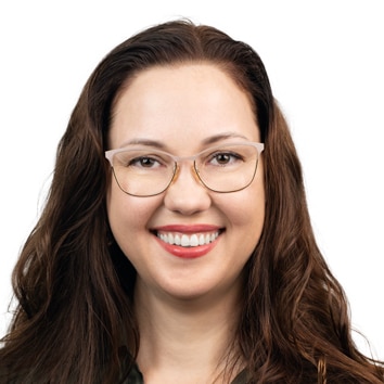 Woman with brown hair and glasses smiling