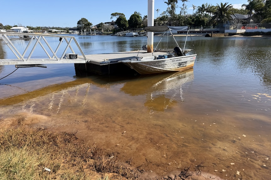 tinny tied to jetty with a brown stain on the bottom