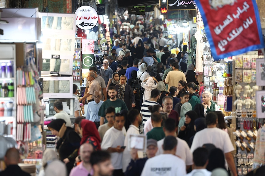 A crowd of people walk in the Grand Bazaar in Tehran, Iran.