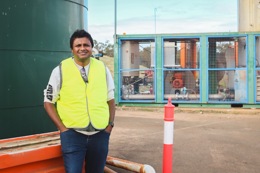 Nadun man in a high-visibility vest standing in an industrial area
