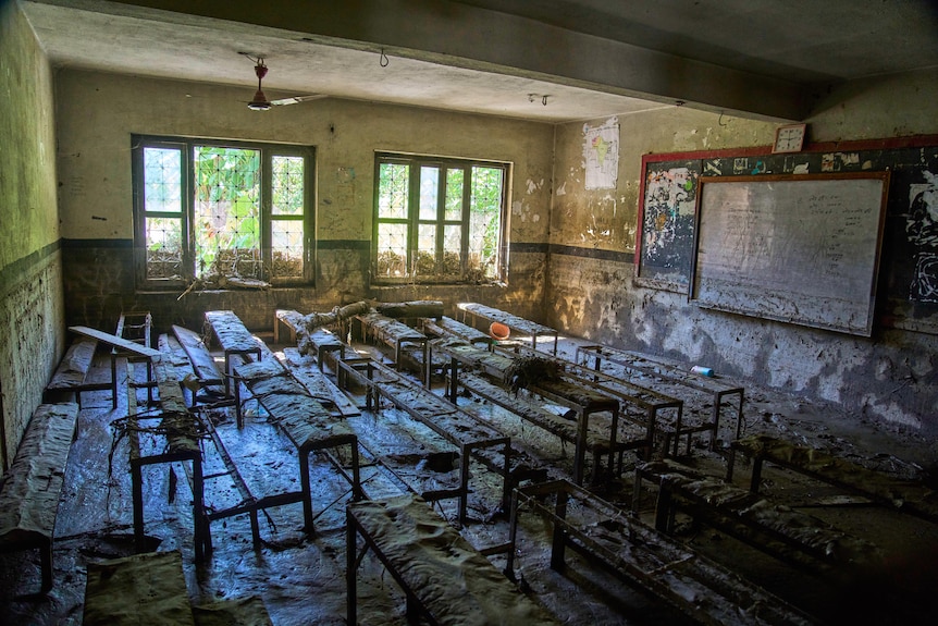 a classroom full of mud, damaged from floods