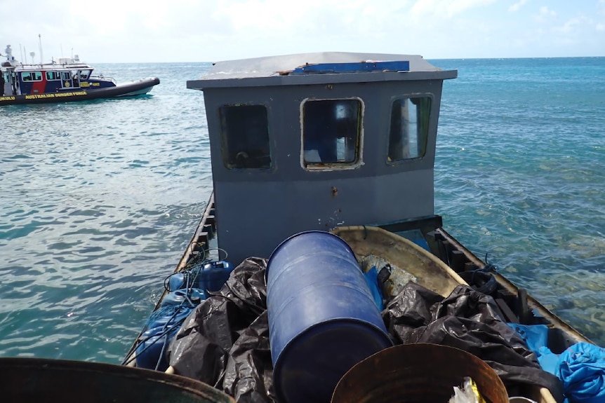 A fishing boat on the water with a Border Force boat in the background