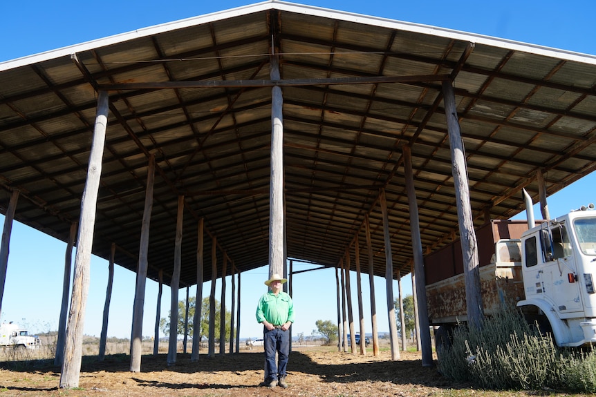 man standing in front of empty hay shed
