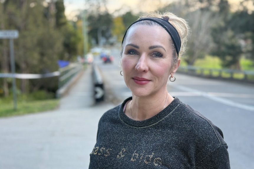 A portrait of a woman standing on a road.