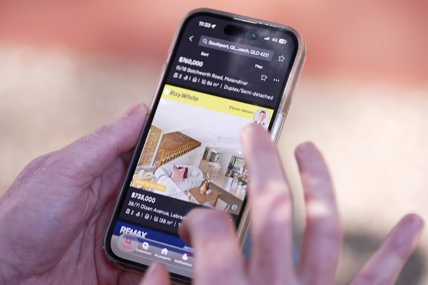 Close up of hand scrolling real estate app