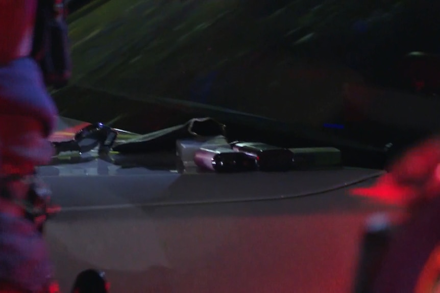 Items on bonnet of white car bright lights around