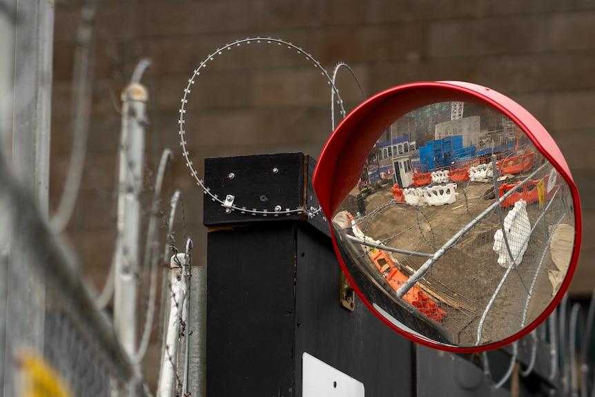 A mirror and barbed wire at a Big Build construction site