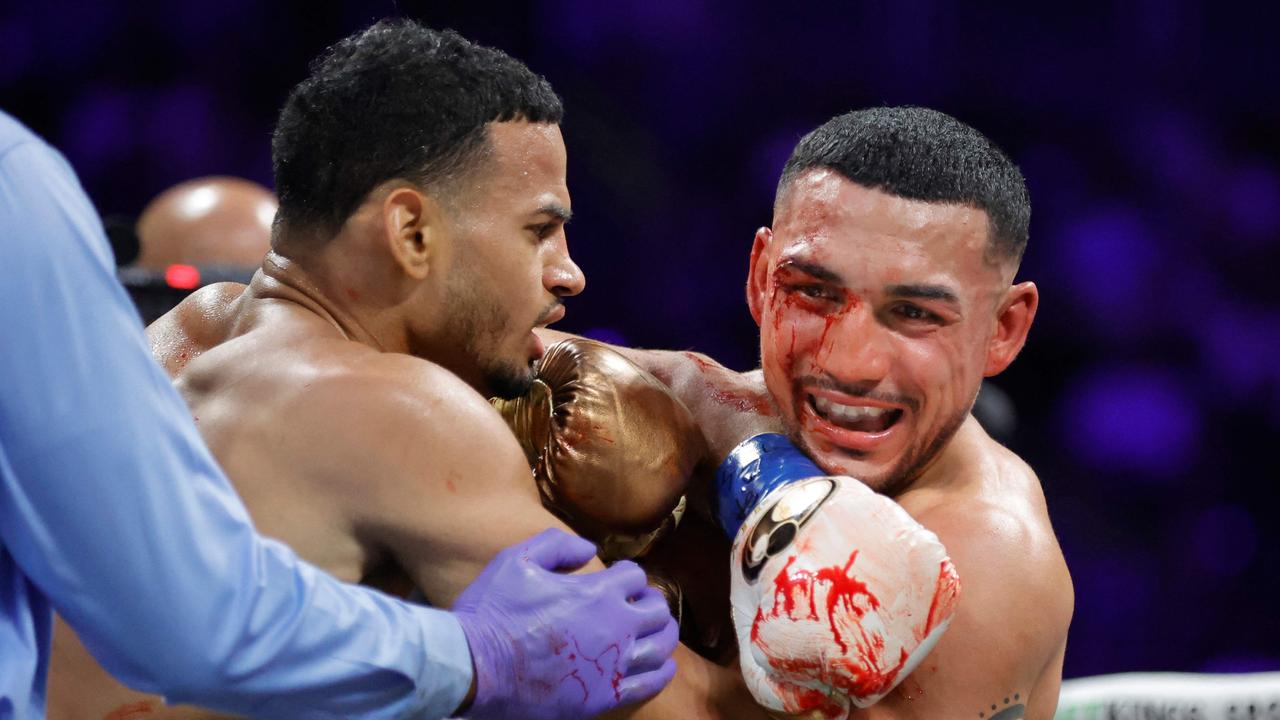 Bloodied star survives scare to outclass rival, complete historic three-division world title feat