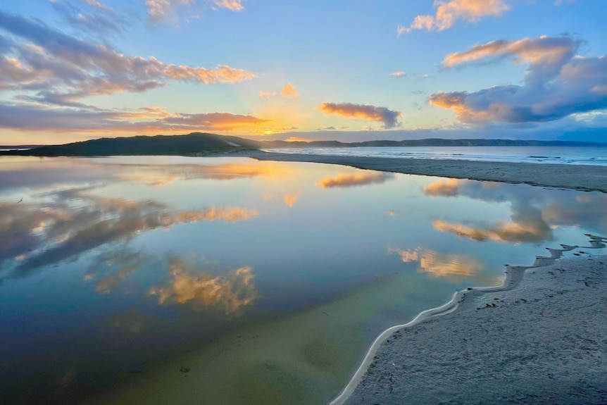 The sun rises over a coastal area