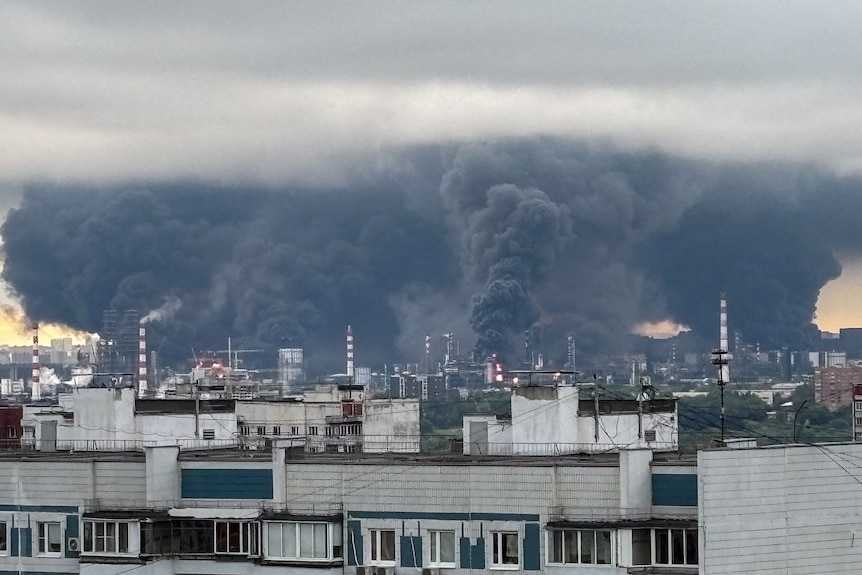 Large plumes of smoke over an oil refinery.