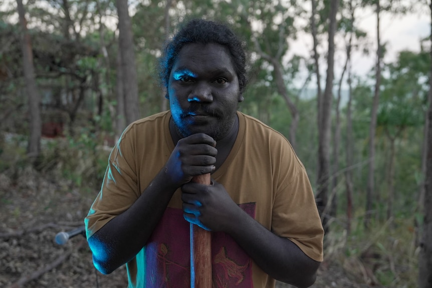 Cloe-up of a young man leaning on a didgeridoo