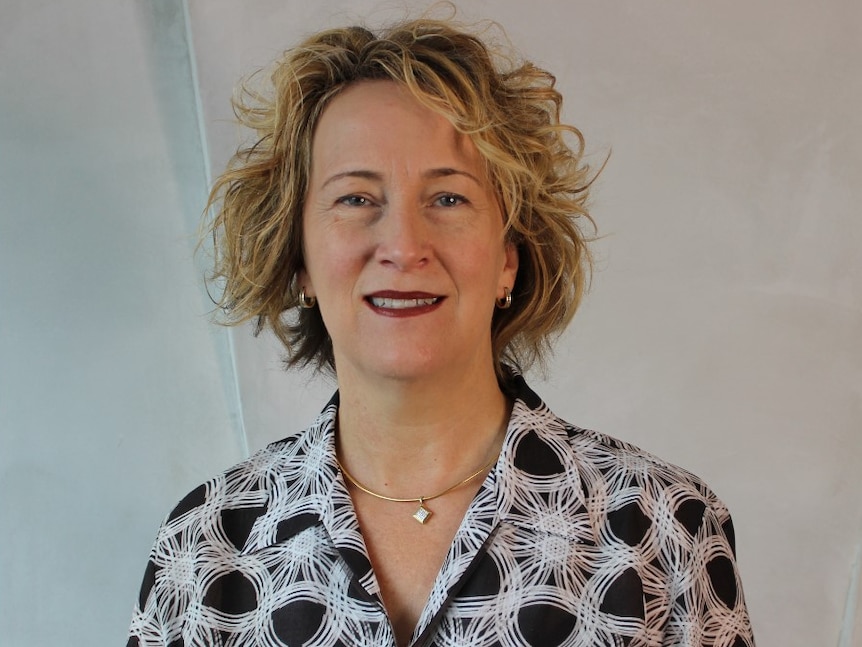 A woman smiles at the camera.