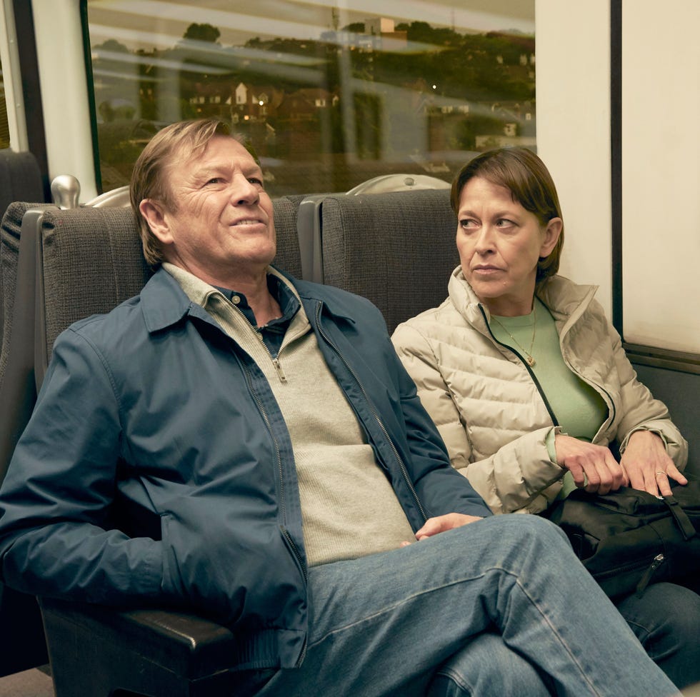 two people sitting on a train, looking in opposite directions. two people sitting on a train, looking in opposite directions.