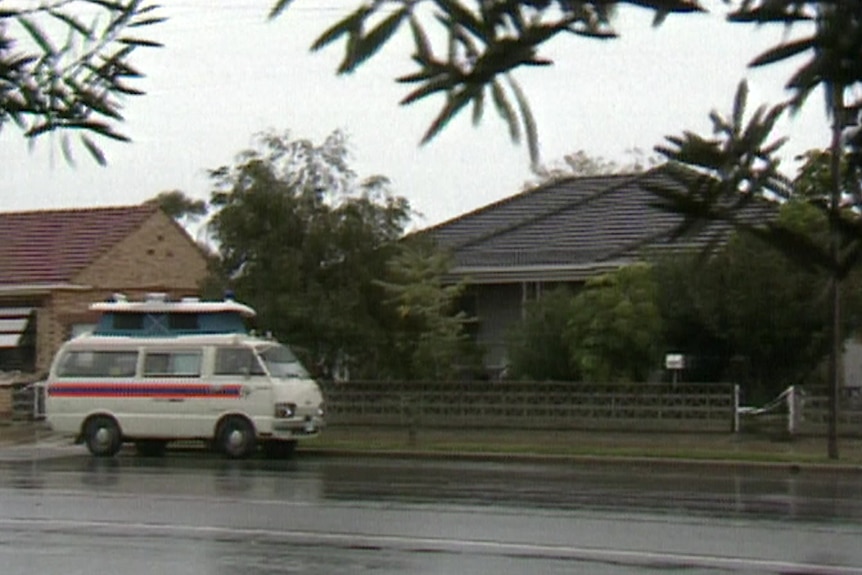A view of a home with a white van outside on a wet street.