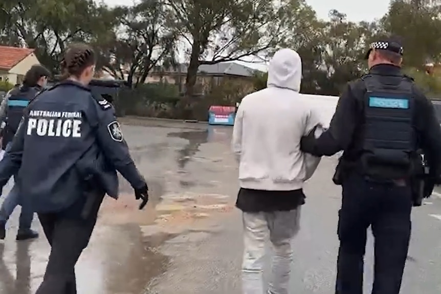 An unidentifiable person being arrested.