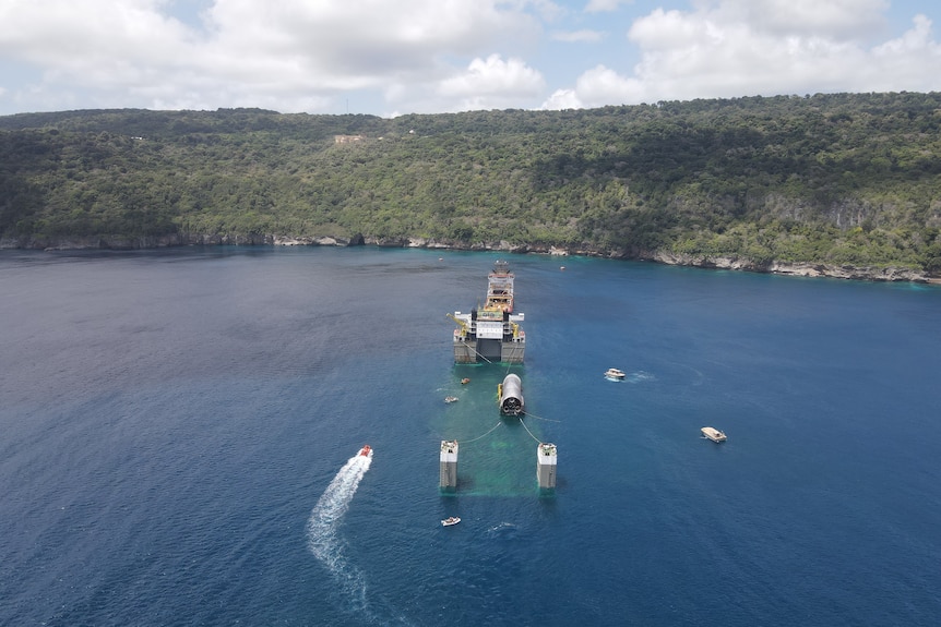 A drone shot of a submerged boat with a boat on it