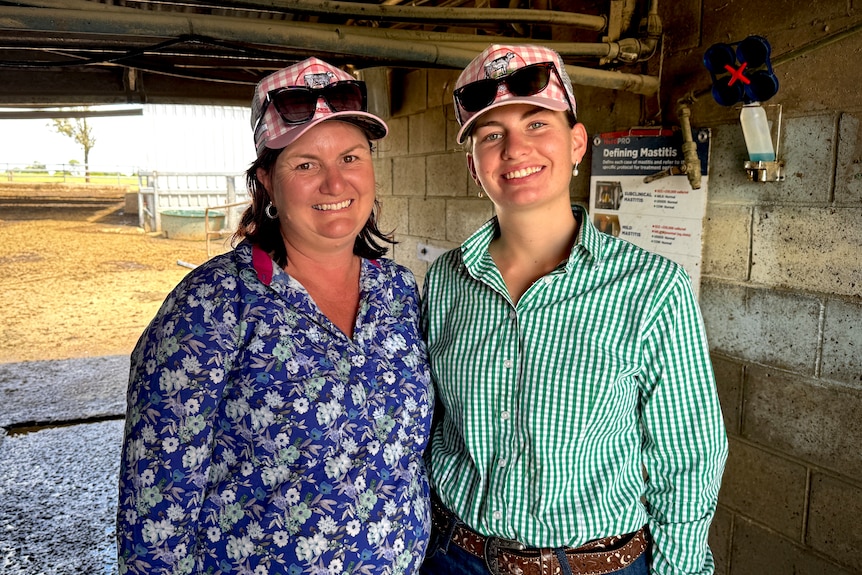 A mum and daughter in a dairy shed.