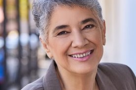A headshot of a woman with short grey hair smiling.