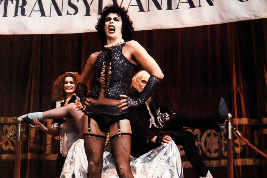 Tim Curry dressed as Dr Frank N. Furter on stage.